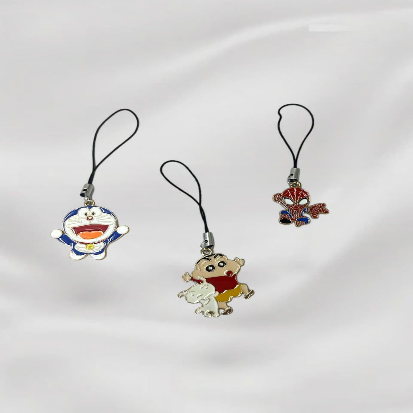 Three cartoon-themed phone charms on a white background