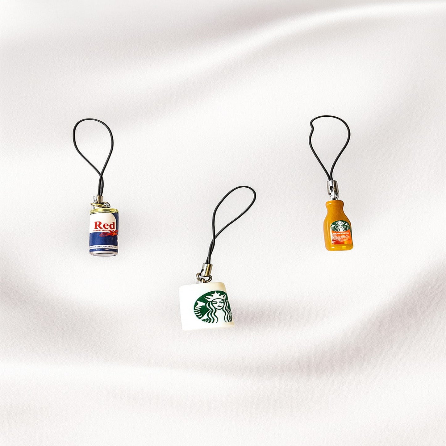 Three small bottle-shaped keychains on a white background