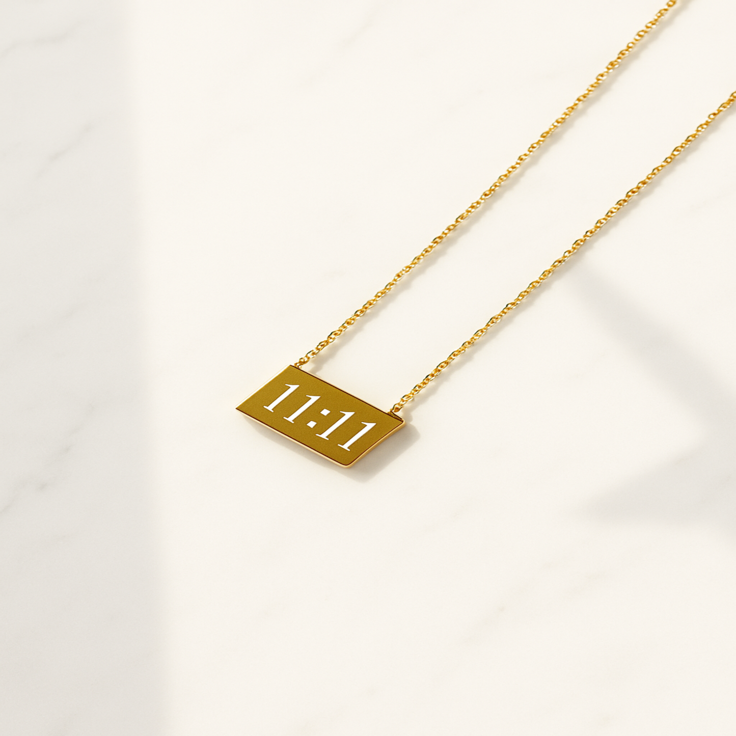 Gold necklace with a rectangular pendant displaying '11:11' on a white background