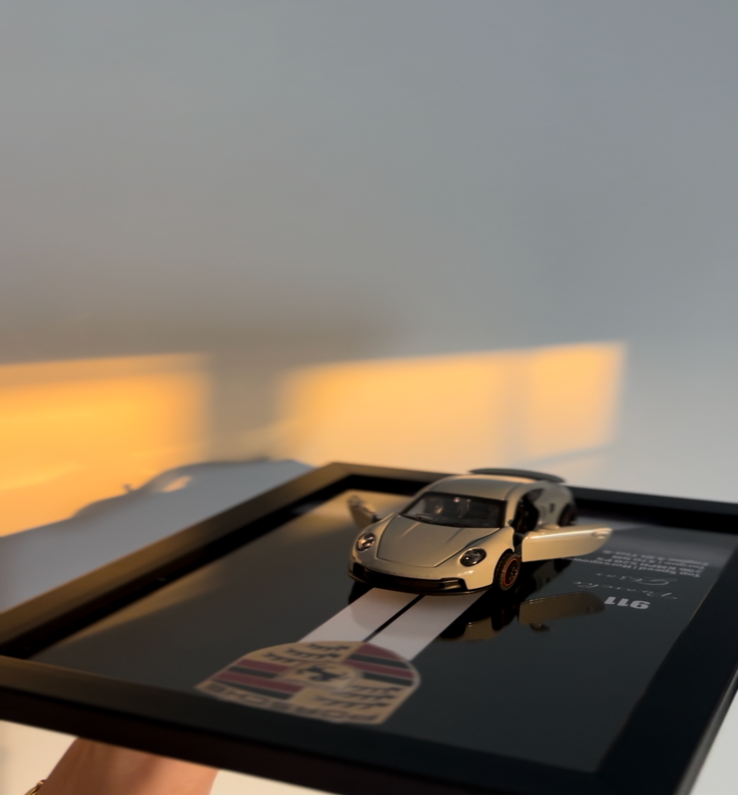 Tablet displaying a car model on a road with a blurred background