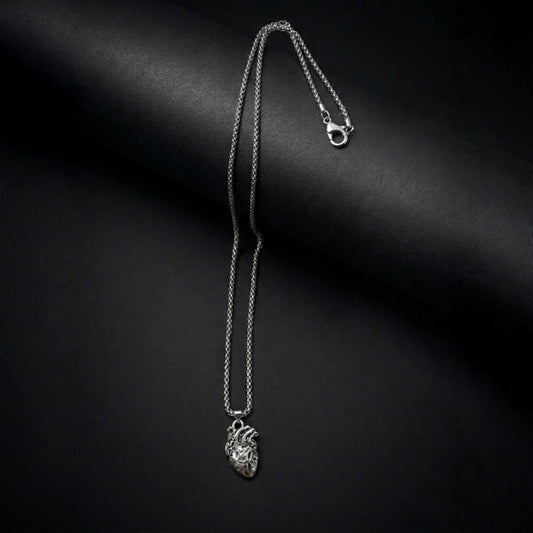 Silver necklace with a heart pendant on a black background