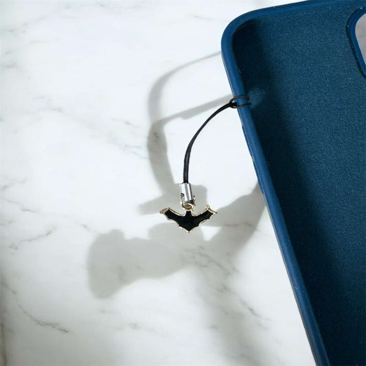 Phone case with a bat-shaped charm on a marble surface - Thecharmingcharms09