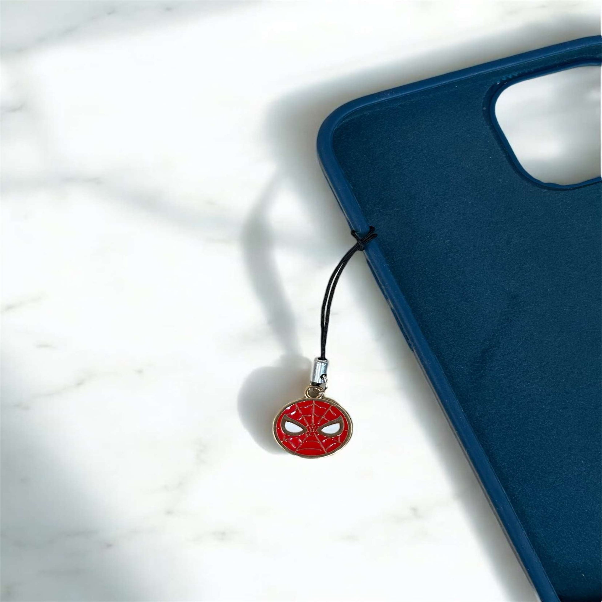 Phone charm with Spider-Man design on a blue phone case against a white background - Thecharmingcharms09